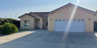 Front view of Fresno senior care home with wide driveway, modern garage, and welcoming entrance.